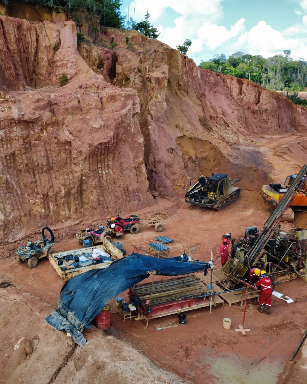 Diamond drill site set beneath an artisanal pit wall, Sela Creek, seen from a drone
