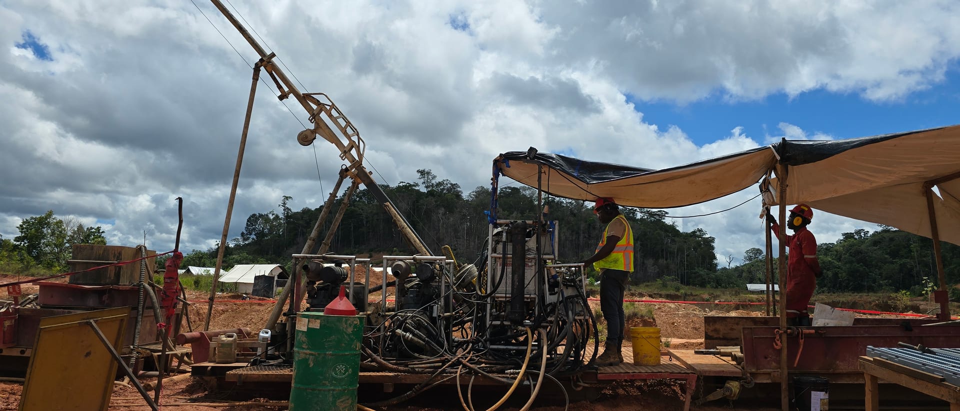 The diamond drill rig and crew under a clear sky at Sela Creek, May 2025