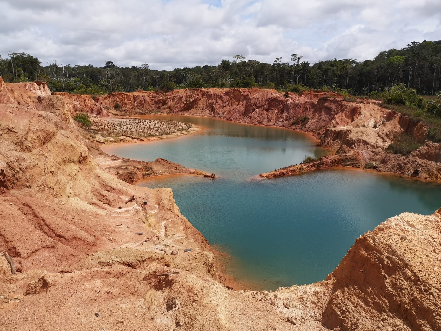 Turquoise lake filling a historic artisanal pit at Jons Pit West, Sela Creek