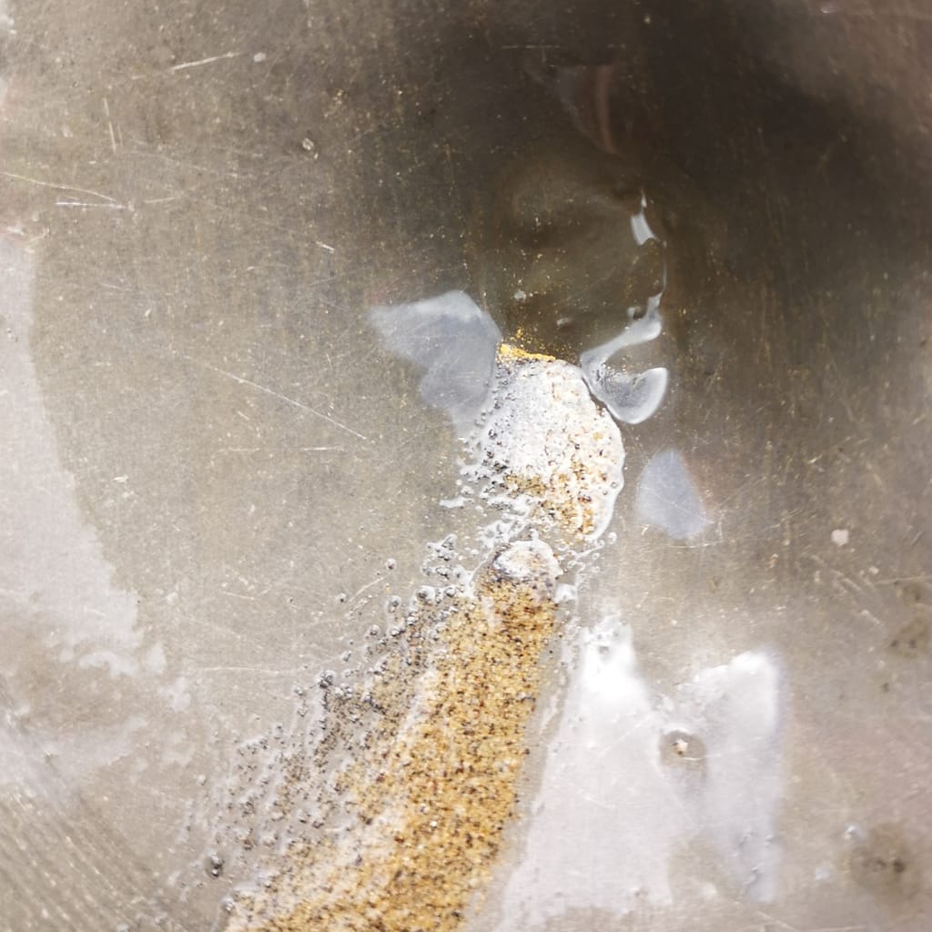Visible gold in a pan from the oxidised zone at the Golden Hand target, Sela Creek