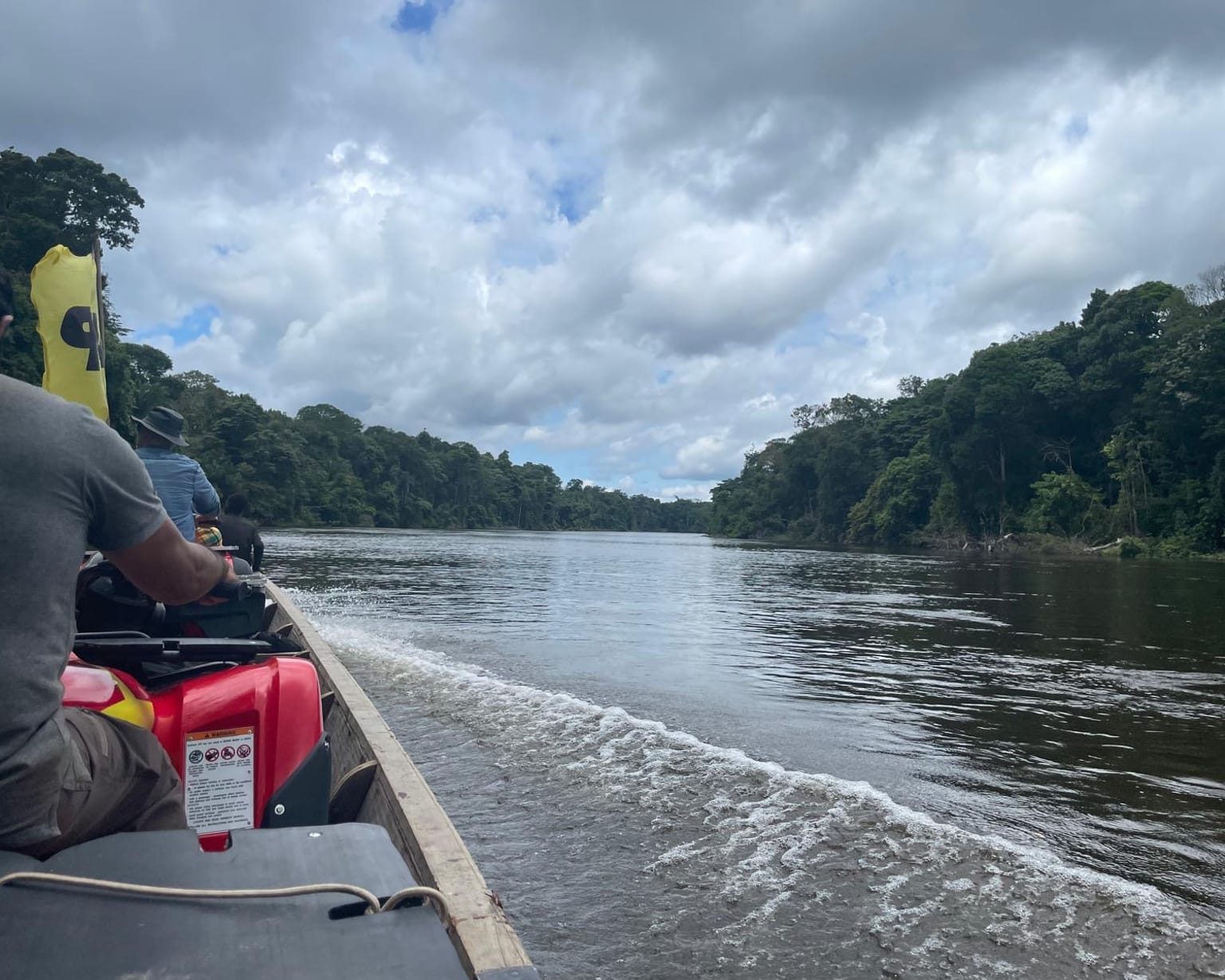 The river commute — a boat carrying a quad up the jungle river to Sela Creek
